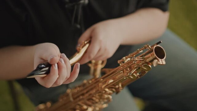 White tutor assembling saxophone neck indoors, careful fitting of neck and mouthpiece, reed and ligature handling, casual seating on carpet, instructional repair and setup scene with calm focus