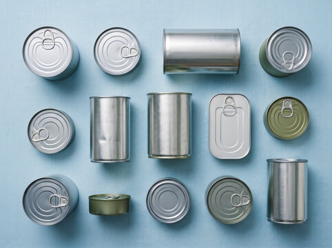 Assorted metal food cans on blue background