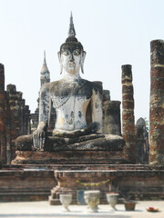 Fototapeta premium Seated Buddha statue at Wat Mahathat in Sukhothai Historical Park Thailand