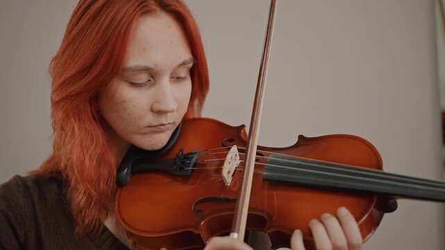 Violinist practicing intensely. Closeup of dedicated player during intimate rehearsal session. Softlit portrait capturing concentrated violinist during private practice moment in studio