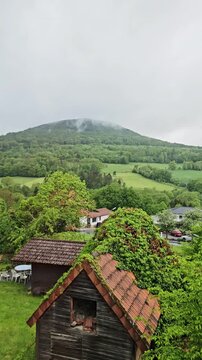 Mountain with fresh green grass in spring. Clouds over and on the mountain. Spring landscape. 2026 Maj, Stadt Tann, Kreis Fulda, Hesse, Germany