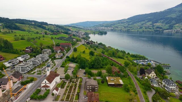 Scenic aerial view of Meggen village and Lake Lucerne with a passing train