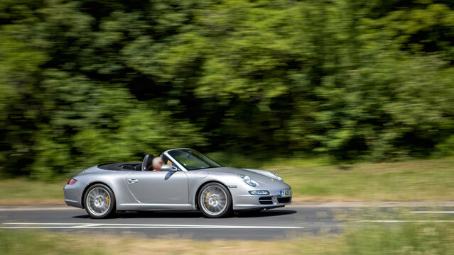 Milton Keynes,Bucks,UK - May 30th: 2005 silver Porsche 911 Carrera Cabriolet 997 convertible car driving on a British road