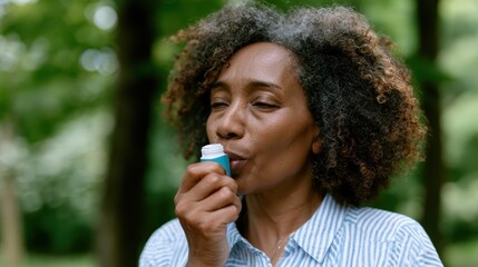 Fototapeta premium close-up of african woman using inhaler outdoors for allergy-triggered asthma, with blurred park backdrop cinematic, realistic, healthcare concept