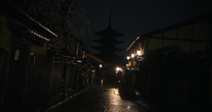 Cinematic silhouette of ancient Japanese village with glowing lamps and light rain