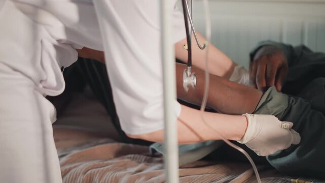 Urgent patient treatment. Doctor secures bleeding at bedside. Medical professional controls bleeding with team effort. Healthcare worker promptly applies tourniquet to manage bleeding