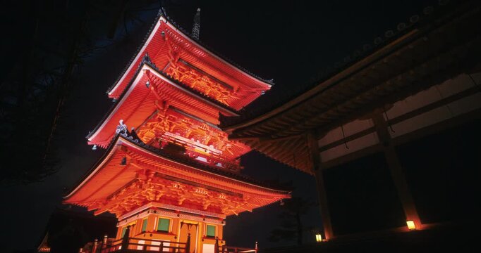Majestic, glowing red Japanese tower at ancient temple - night