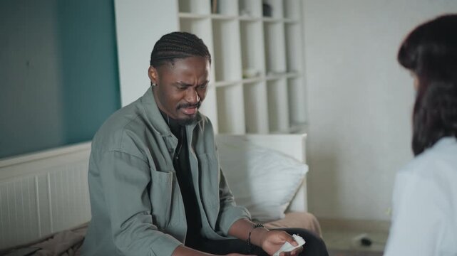 Man discusses symptoms with nurse. African American man consults nurse about his medical condition. Gentleman of color engages in health discussion with medical professional in calm setting