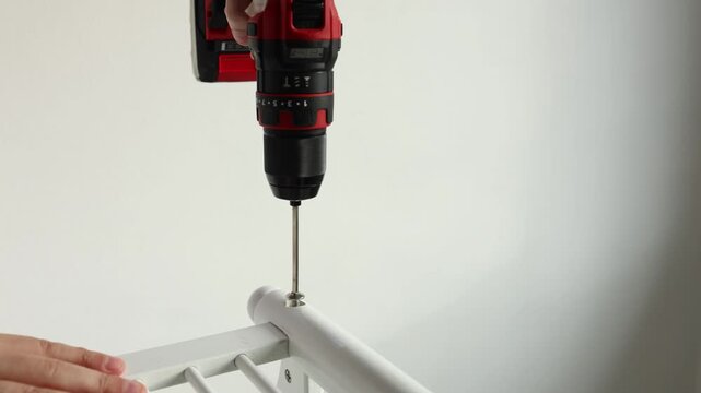 Assembly of furniture using cordless drill screwdriver close up