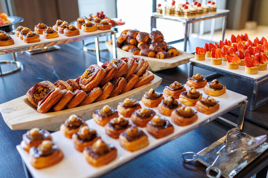 An indulgent array of gourmet pastries, including pecan danishes, berry turnovers, and fresh strawberry tarts. I