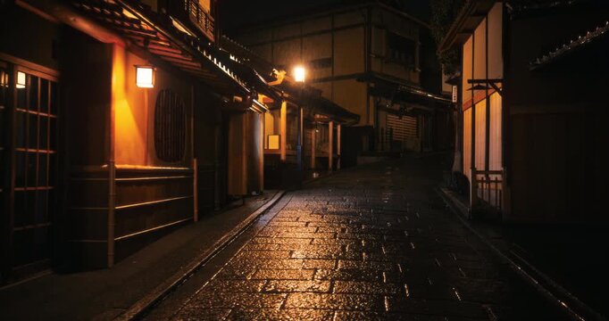 Steady cam movement through empty, wet cobblestone road in ancient Japanese village at night