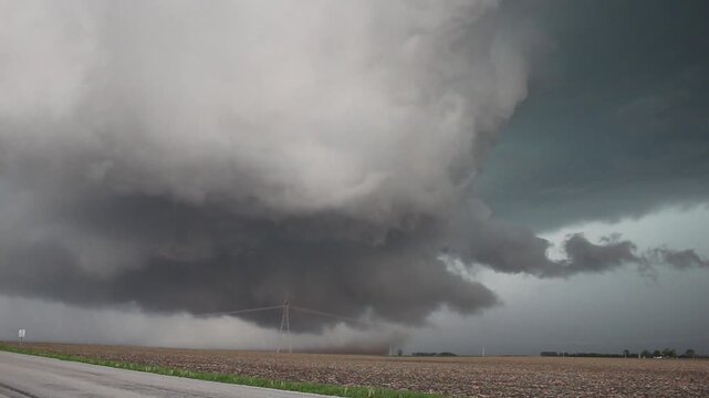 A dangerous supercell storm approaches, stirring up dust in a field as it attempts to form a tornado. Time lapse footage.