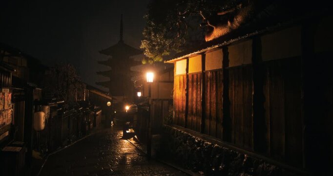 Rain falling on empty, old Japanese town at night - wide shot