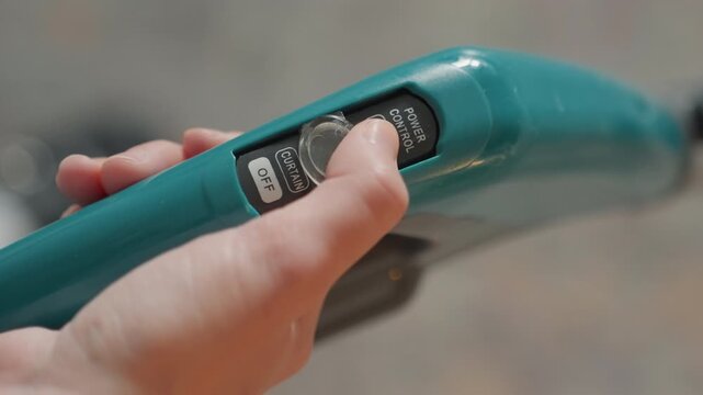 Hand adjusting steamer digital dial display, preparing unit for house cleaning, close kitchen background, thumb rotating control, illuminated icons, practical efficient prep, focused active mood,