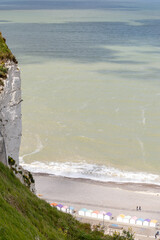 Obraz premium Views of ocean beach and colourful beach huts or cabins in Le Treport, seaside resort in Normandy, France, with white cliffs along English Channel, travel destination in France