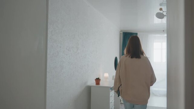 Woman organizes desk and lighting. Individual sets up environment for focused studying. Caucasian woman arranges furniture and opens curtains to enhance natural illumination for studying
