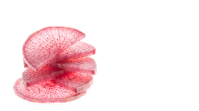 Fresh organic watermelon radish slices stacked on white background