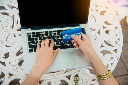 Female freelance reading financial graph charts Planning analyzing marketing data. Business woman using smartphone, laptop on office desk. Hands of young woman working in office firm business info.