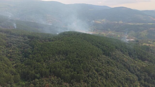 Vertical screen, Vietnam, Da Lat Aerial Glimpse Of Billowing Smoke Haze. Observation Of Ascending Smoke And Light Atmospheric Fog. Aerial Perspective Capturing Drifting Smoke Plumes Moving