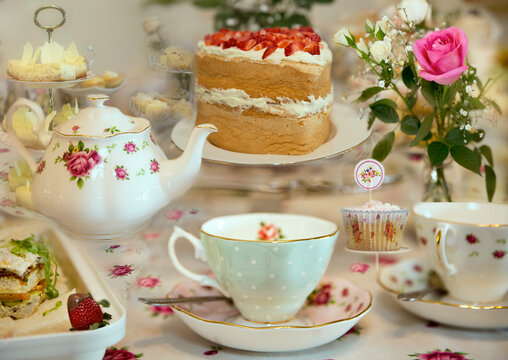 Traditional afternoon tea spread with floral china, cakes, sandwiches and sweet treats.