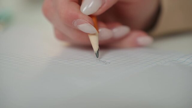 Closeup hand writing grammar worksheet home, tutor guiding pencil tip over dotted lines, neat manicure and focused fingertip, soft warm indoor lighting with shallow depth of field, calm cozy study