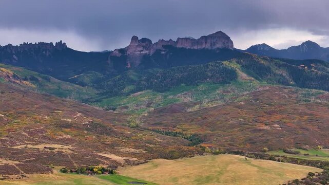 Panoramic aerial view of Colorado fall landscapes featuring mountain fall foliage trees while capturing beauty of Chinmey Rock and Courthouse Mountain in the San Juan Mountain wilderness - 4K Drone