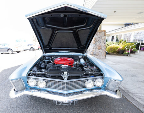 Vancouver, WA, USA - April 26, 2023 - Under hood view of a 1963 Buick Riviera Wildcat 445 V8 engine bay featuring radiator, battery, hoses, wiring, and restored factory style components