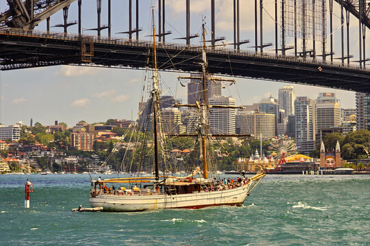 Sailing ship passing by Sydney Harbour Bridge, Australia