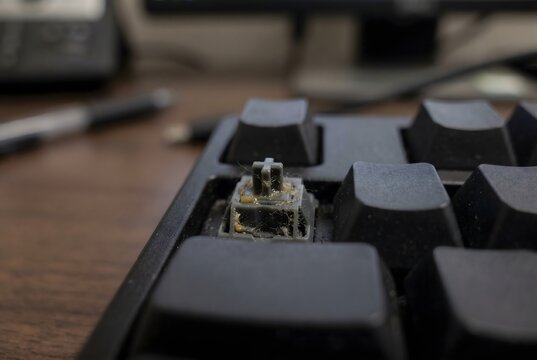 Full frame texture of exposed mechanical keyboard switch stem with removed keycap and micro dust