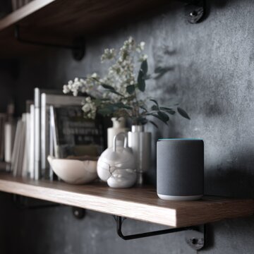 Minimalistic interior design with tech savvy features. Ai being. Enhanced decor: smart speaker on a chic shelf setting. Mechanical being. Digital consciousness.