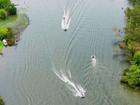 Aerial view of speedboats and water skiers on an inland river