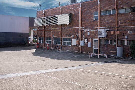 rear wall of comercial building with utilities, the carpark is in the foreground
