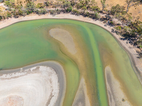 Aerial view of colourful water channels in a drying reservoir