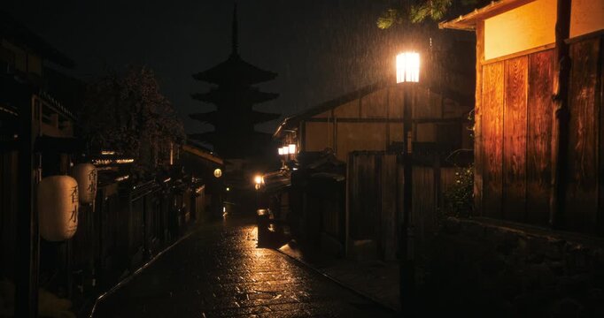 Smooth movement through ancient, shadowy Japanese village at night as it rains