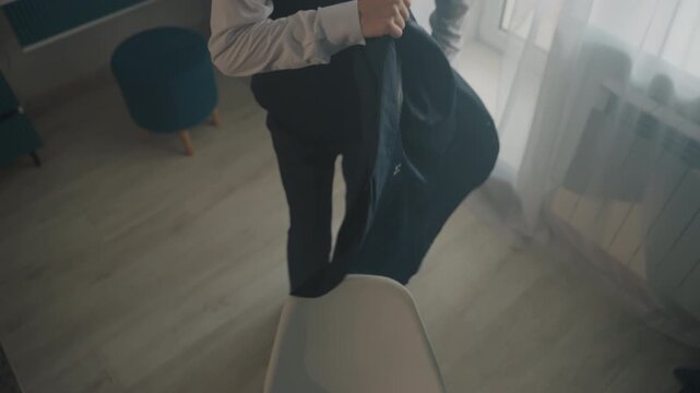Caucasian man buttoning suit vest, morning hotel room with soft natural light through curtains, mirror reflections, curly hair, adjusting tie, closeups of hands fastening buttons, intimate cinematic