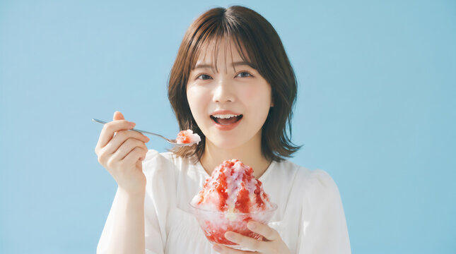 Smiling young Asian woman eating a strawberry shaved ice with condensed milk