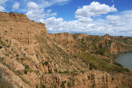 Ein felsiger Canyon mit einem klaren blauen Himmel und wei&szlig;en Wolken dar&uuml;ber, Barrancas de Buruj&oacute;n, Burujon, r&iacute;o Tajo, Fluss Tajo, embalse de Castrej&oacute;n, Stausee de Castrejon, Toledo, Kastilien-La Mancha, Spanien