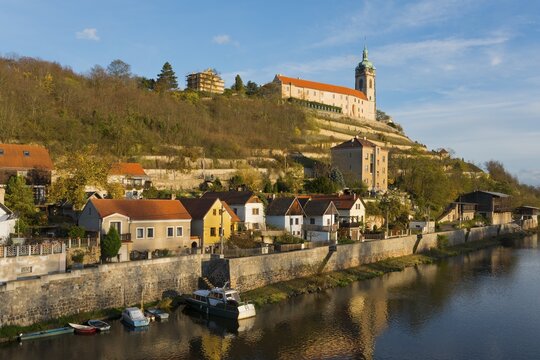 Idyllic town view with church on a hill by the river in the evening sun, surrounded by autumnal nature, Melnik Castle, Church of St. Peter and Paul, Melnik, Melnick, River Elbe, Central Bohemia, Czech Republic