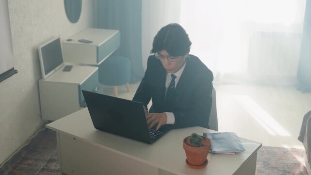 Man in suit working at bright desk with sunlight streaming through window, potted plant and papers nearby, drafting ideas and edits, calm creative atmosphere, notebook and coffee on surface