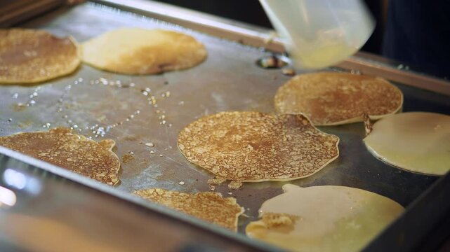 Cooking pancakes on a hot griddle in a local kitchen