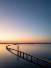 Fototapeta premium [Generative AI] Aerial view of a large cable-stayed bridge over a calm sea at sunset