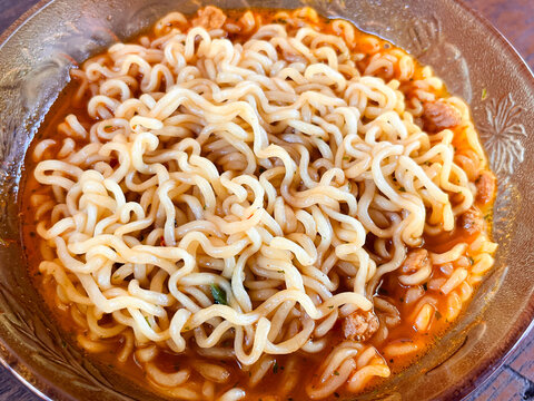 a Bowl of spicy instant noodles soup. Isolated by wooden background or table. Close up shot. Very delicious asian foods