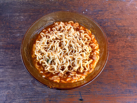 a Bowl of spicy instant noodles soup. Isolated by wooden background or table. Top-view angle. Very delicious asian foods