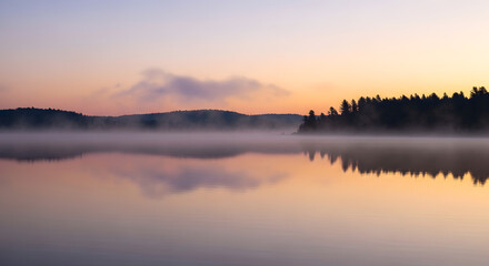 Obraz premium Serene Sunrise Over Calm Lake with Misty Forest Reflection