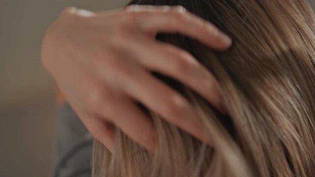 Closeup brown bob haircut caucasian woman, stylist hand adjusting glossy strands under warm light, precise trim at nape, intimate grooming scene showing calm elegance, professional salon atmosphere