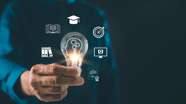 lightbulb graduation study creative idea solution online education icons glow around man hand holding bulb, representing knowledge and success plus skills training for academic growth