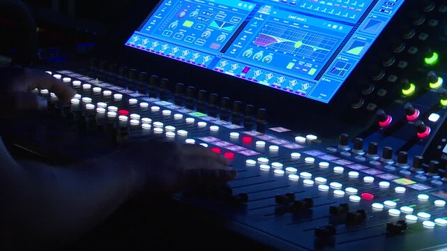 Live Audio Mixing Console With Touchscreen Interface and Hand Adjusting Controls During Concert Production
