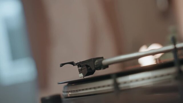 Gentle glow illuminating tactile record grooves. Nostalgic scene capturing stylus interacting with vinyl surface. Warm ambient light emphasizing intimacy of analog record playing experience