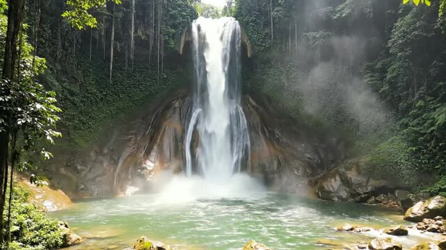 Scenic waterfall cascading into a crystal clear pool amidst lush tropical rainforest with beautiful sunlight.
