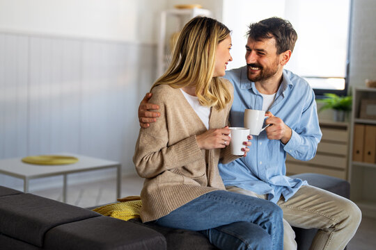 Loving couple enjoying a calm morning at home with coffee, smiling and sharing a peaceful moment